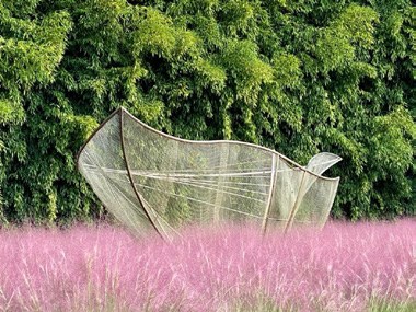 Escultura entre flores rosas